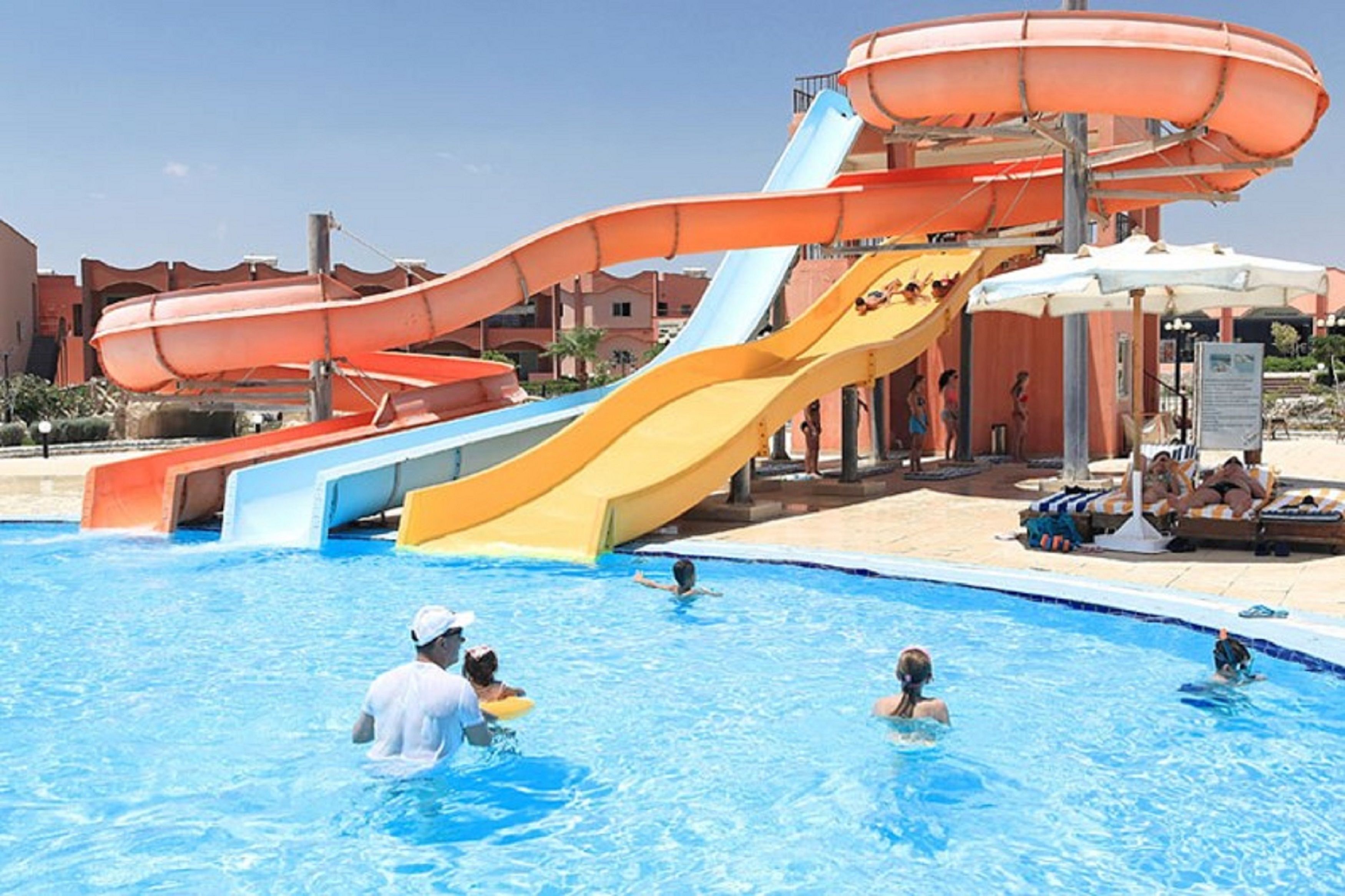 A swimming pool with multiple water slides and lounge areas.