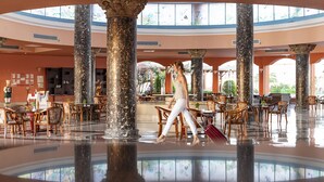 A spacious lobby with high ceilings, large columns, and a central reception desk. - Three Corners Happy Life Beach Resort - All Inclusive (Marsa Alam)