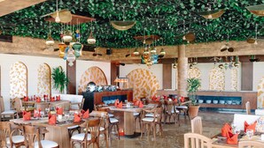 A restaurant with multiple dining tables, chairs, and hanging decorative lights. - Three Corners Happy Life Beach Resort - All Inclusive (Marsa Alam)