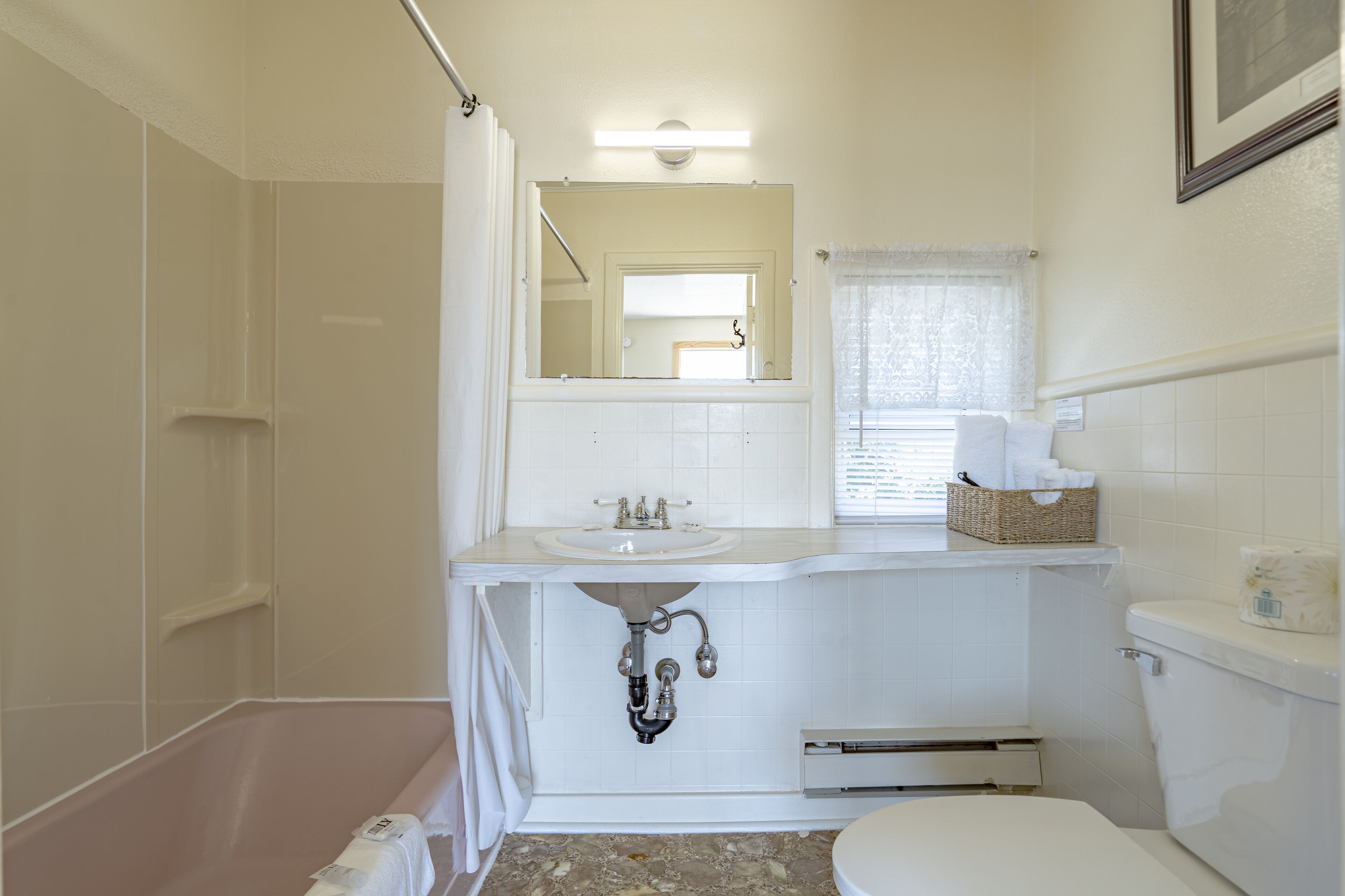 Un bagno con vasca, lavabo, servizi igienici e specchio sopra il lavabo.