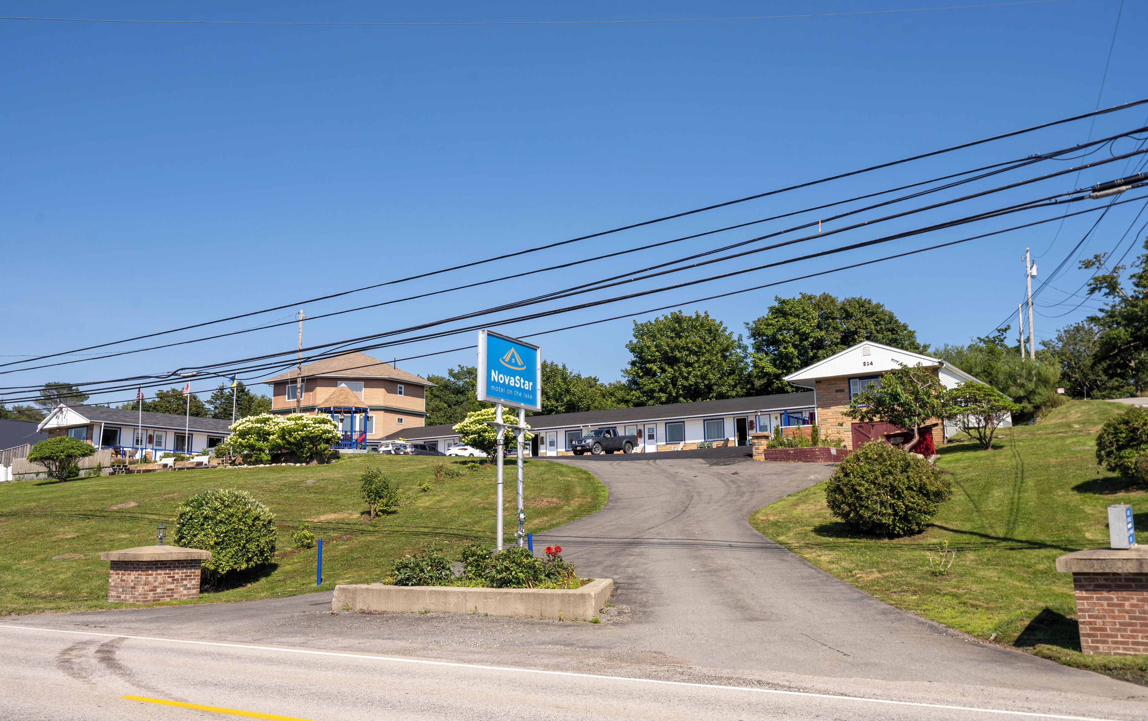 Un motel con un letrero que dice "NovaStar motel en el lago", un estacionamiento y una carretera que lleva al motel.