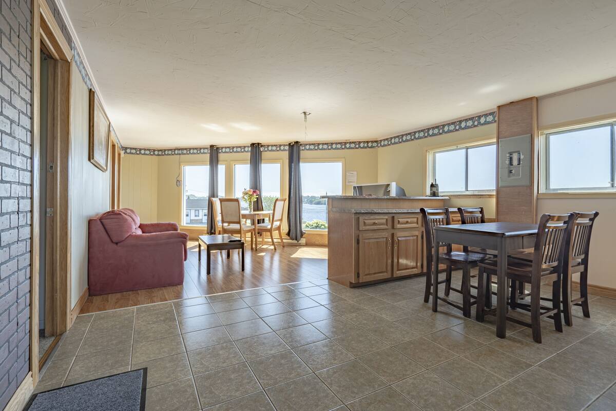 Una cocina amplia con comedor, sofá y vistas al exterior.