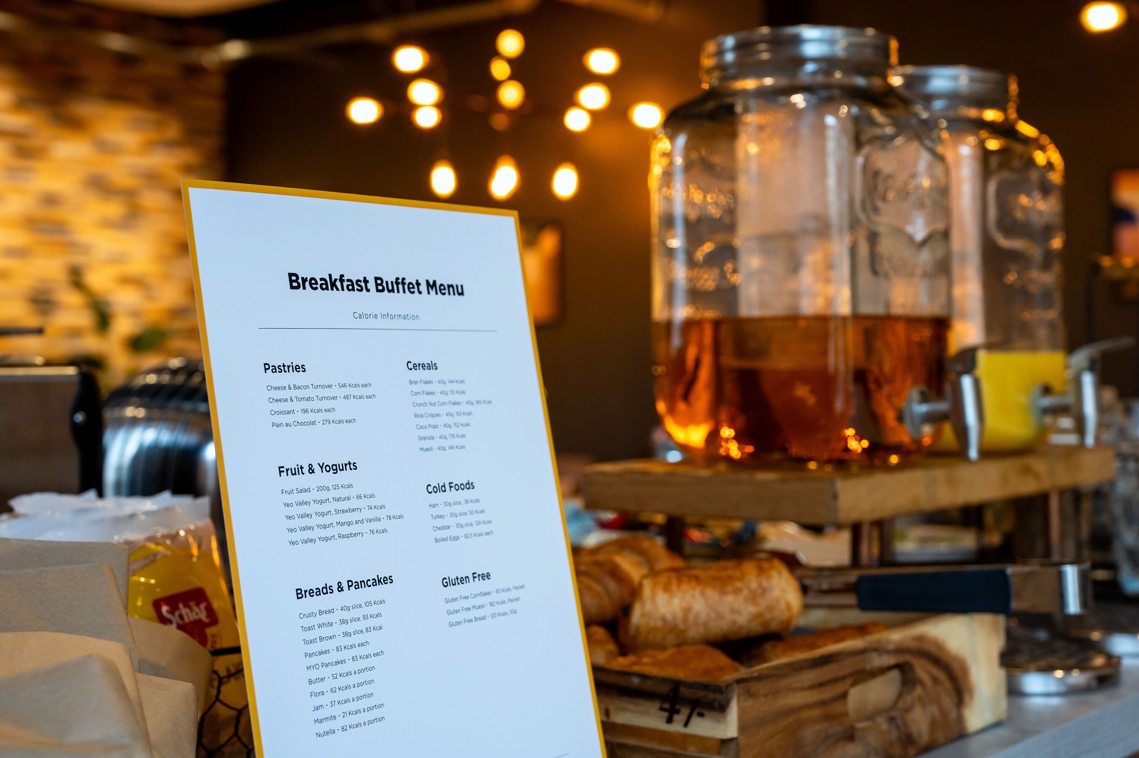 A breakfast buffet menu with sections for pastries, fruit & yogurts, breads & pancakes, and gluten-free options.