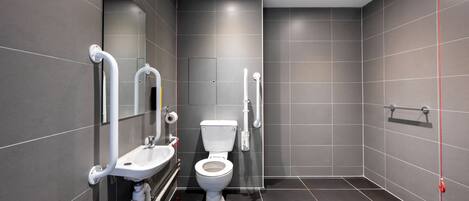 A modern bathroom with a toilet, sink, and shower area.