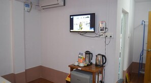 A small room with a television mounted on the wall, a coffee maker, and a small table with a kettle and cups. - Royal Diamond Hotel (Mandalay)