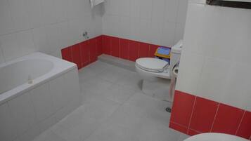 A bathroom with a bathtub, toilet, and sink.