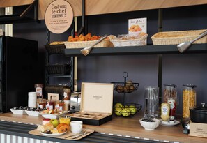 A breakfast buffet with various food items and condiments. - B&B HOTEL Compiègne Thourotte (Thourotte)