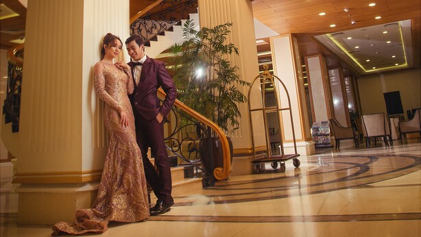A grand lobby with a chandelier, a staircase, and a reception area. - Hotel Hazel (Mandalay)