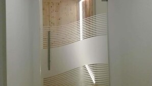 Un pasillo con piso de madera, paredes blancas e iluminación empotrada en el techo.
