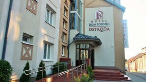 Entrada de un hotel con un letrero que dice "HOTEL DOM POLONII OSTRODA".