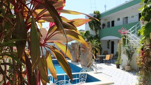Un patio con piscina, mobiliario exterior y una escalera que conduce a un nivel superior.
