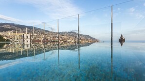 Vista panorámica de una ciudad costera con cielo despejado, un puente y la aguja de una iglesia.
