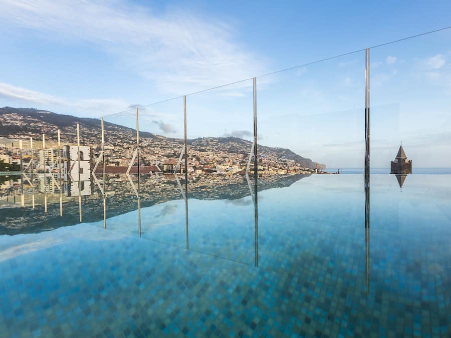 Alberca techada, alberca al aire libre y sombrillas en la alberca