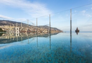 A panoramic view of a coastal city with a clear sky, a bridge, and a church spire. - Castanheiro Boutique Hotel (Funchal)