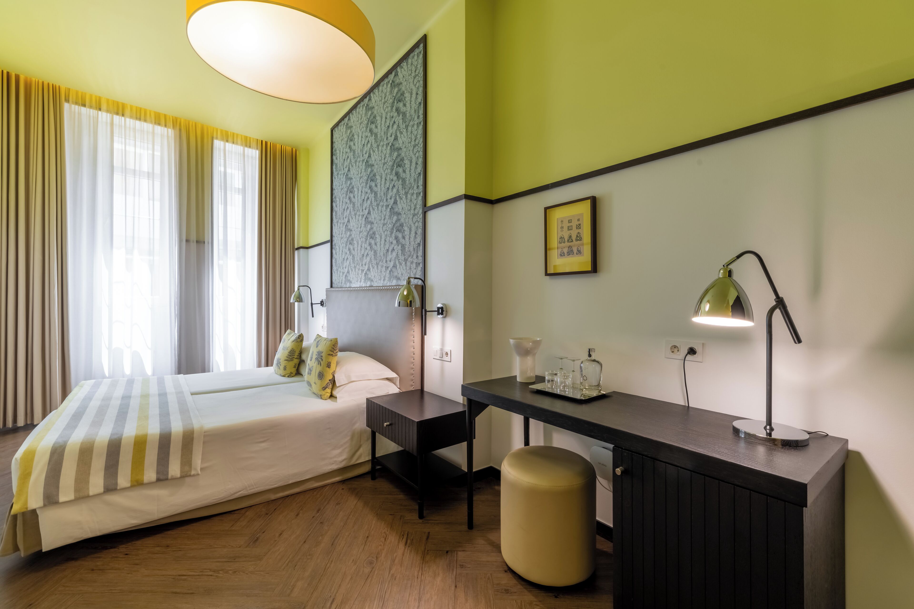 Une chambre d’hôtel comprenant un lit, une table de chevet, un bureau et une chaise.