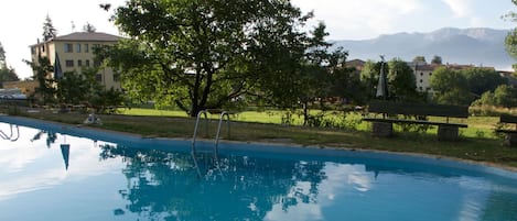 Una piscina al aire libre, sombrillas, tumbonas