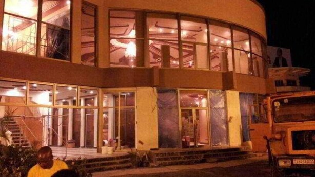 A multi-story building with large windows and a staircase leading to the entrance. - Beatrice Hotel (Kinshasa)