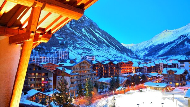 A snow-covered mountain town with wooden buildings and a ski resort.