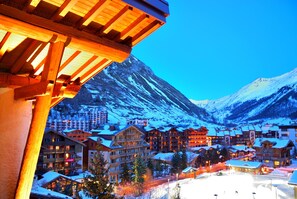 A snow-covered mountain town with wooden buildings and a ski resort. - Hôtel Christiania (Val-d'Isere)