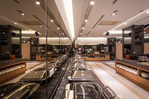 A modern hotel lobby with a long buffet line, marble counters, and a mirrored wall reflecting the space. - FM Hotel (Taichung)