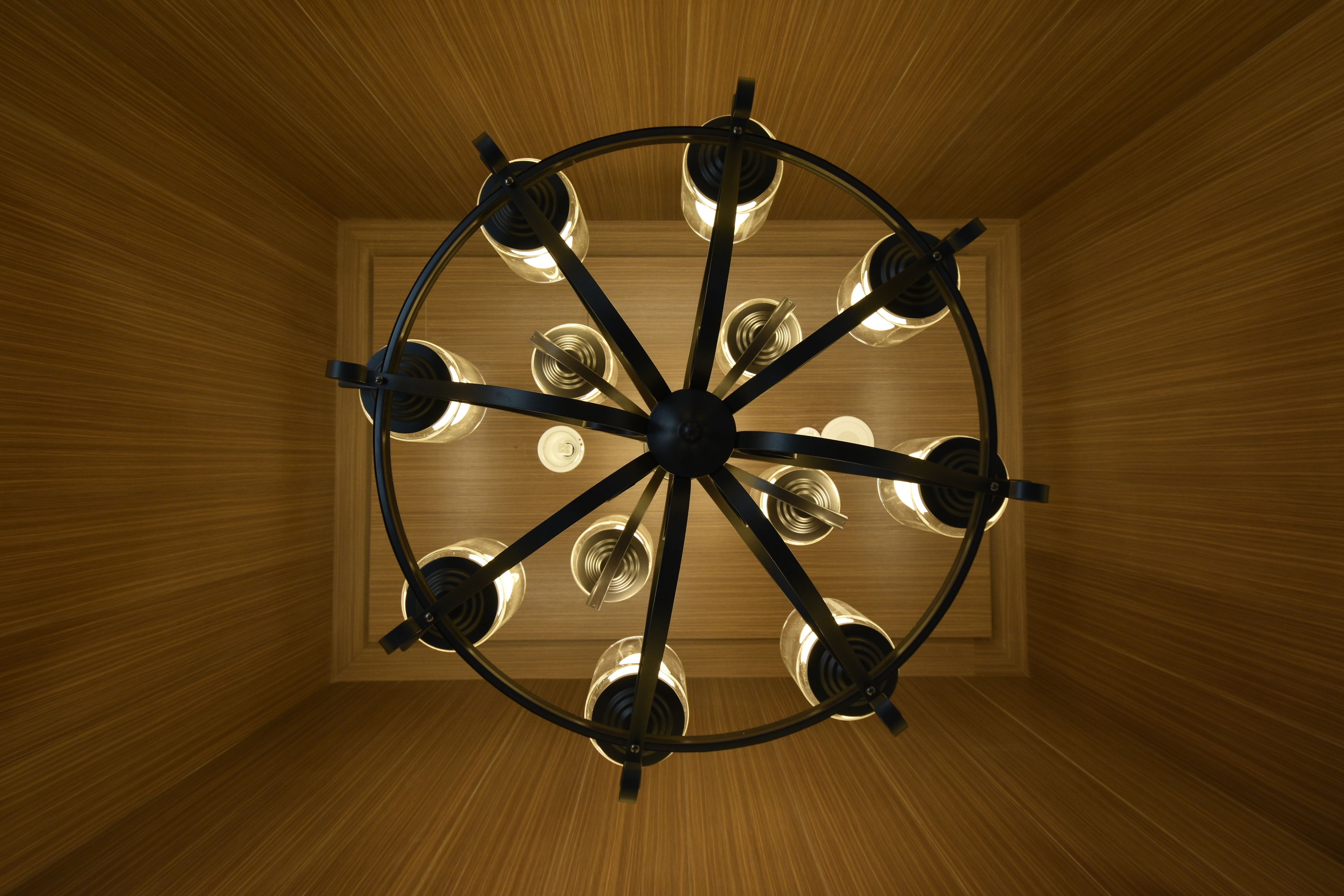 Un plafond orné d’un luminaire circulaire comportant plusieurs ampoules.