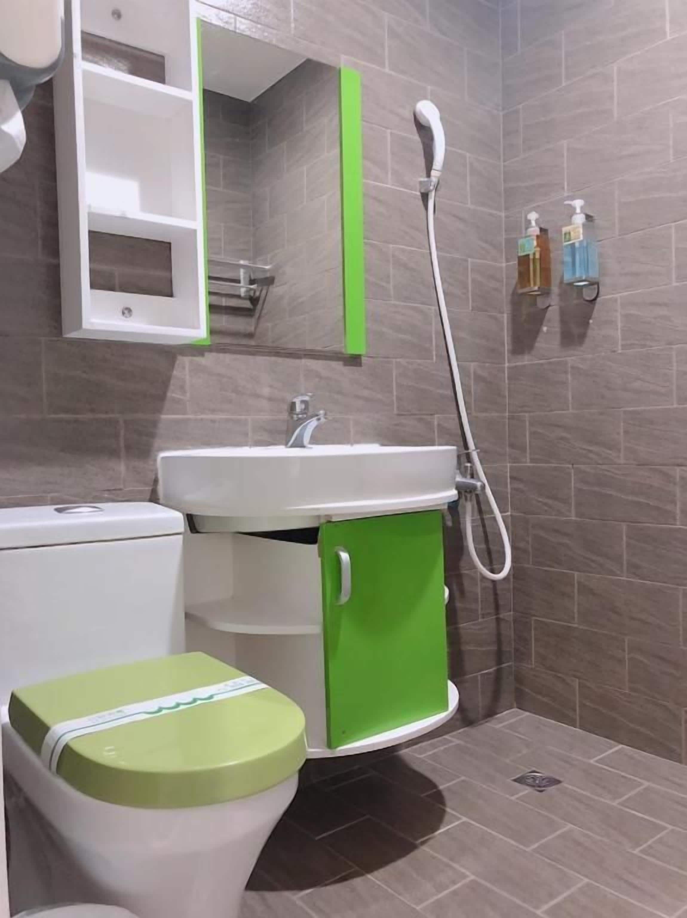 A bathroom with a toilet, sink, and shower.