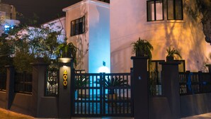 A gated residential area with a modern white building, a visible number '400', and a well-lit entrance. - The Lot Boutique (Lima)