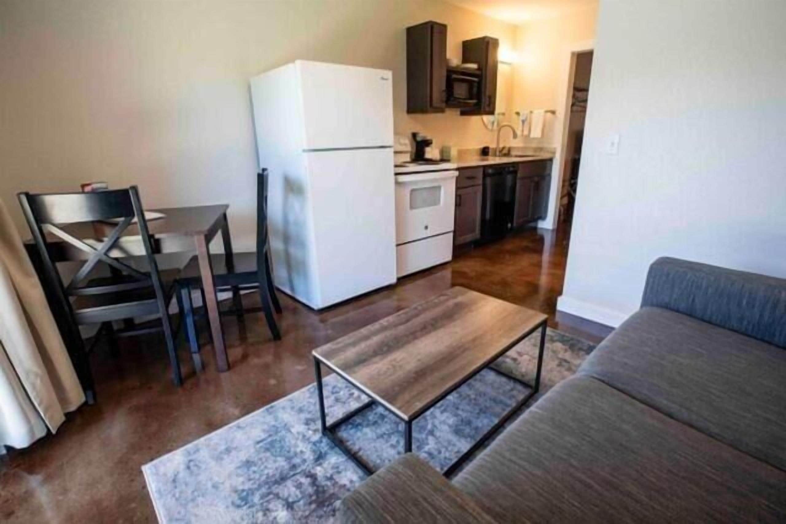 Un espacio habitable compacto con kitchenette, comedor y zona de estar.