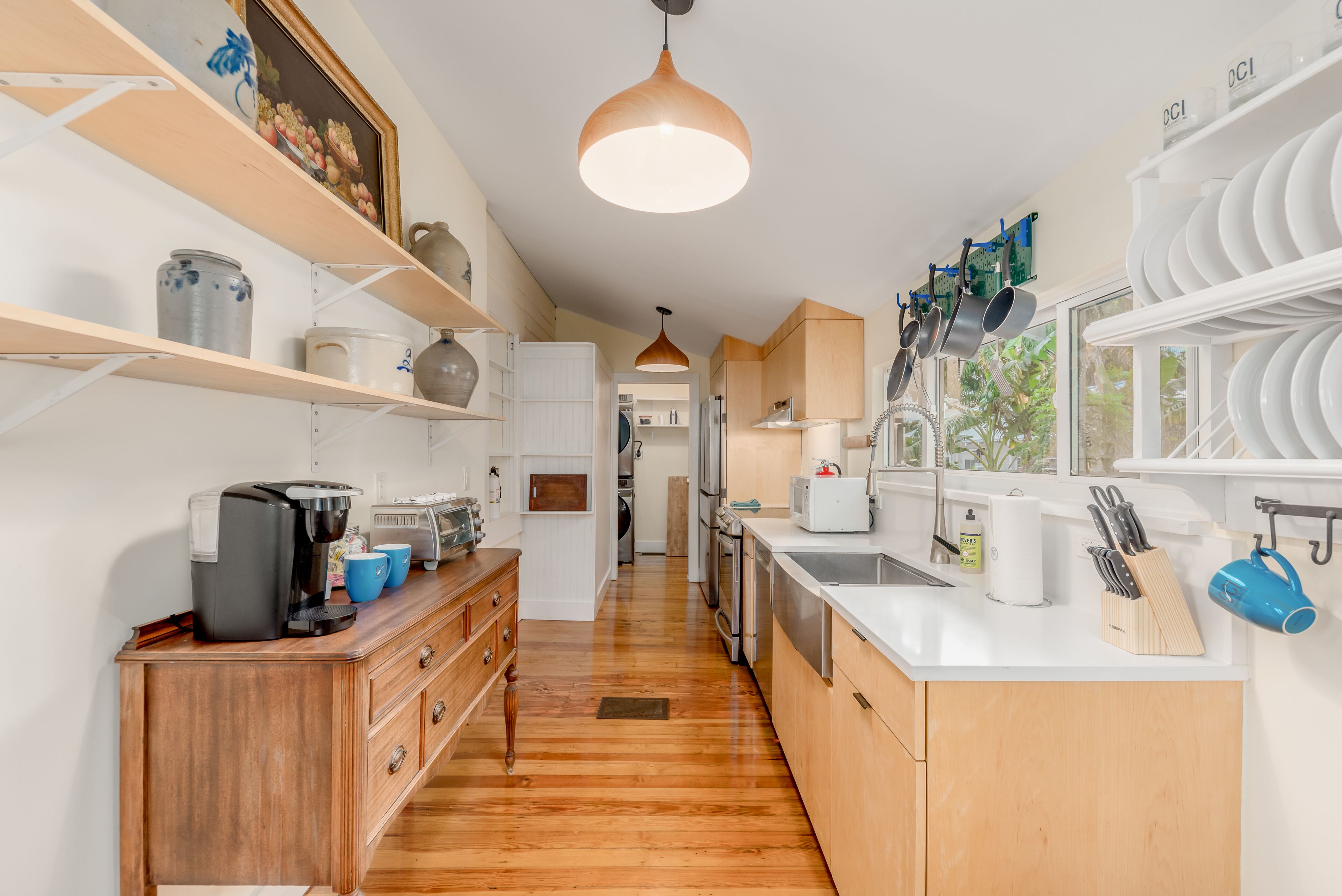 A modern kitchen with wooden cabinets, a coffee maker, and a sink.