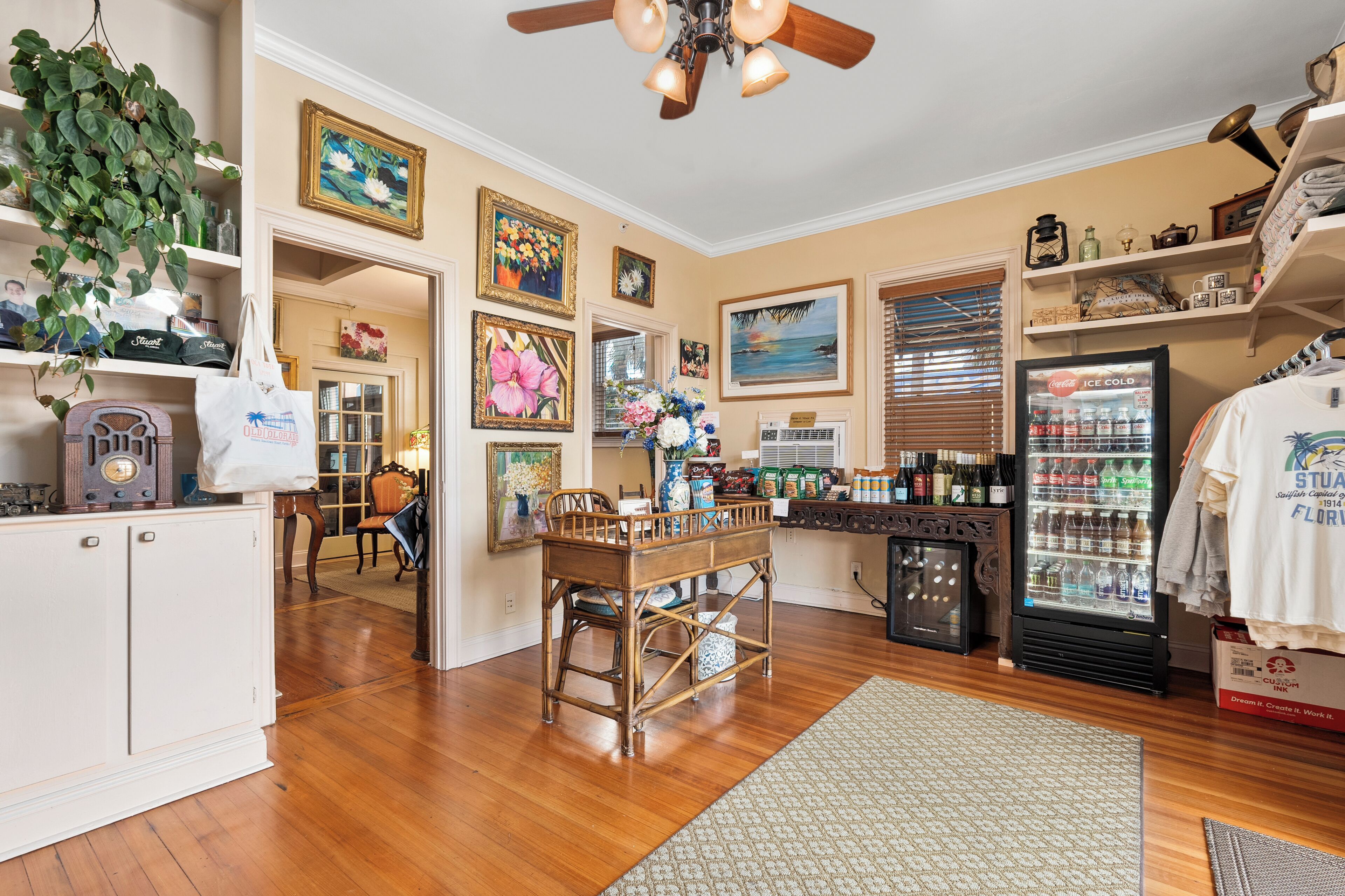 A well-lit kitchen with wooden cabinets, a dining table, and a refrigerator stocked with beverages.