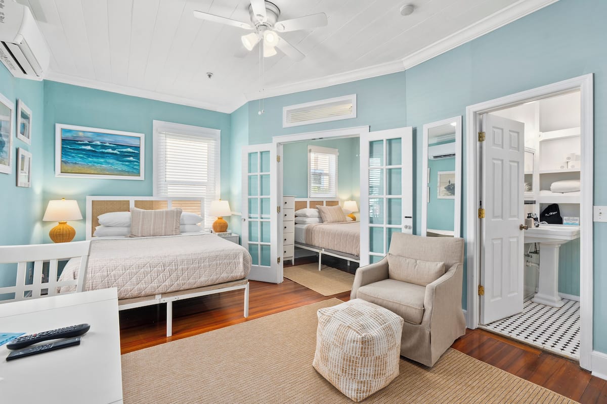 A bedroom with a bed, bedside tables, a chair, and a wardrobe.