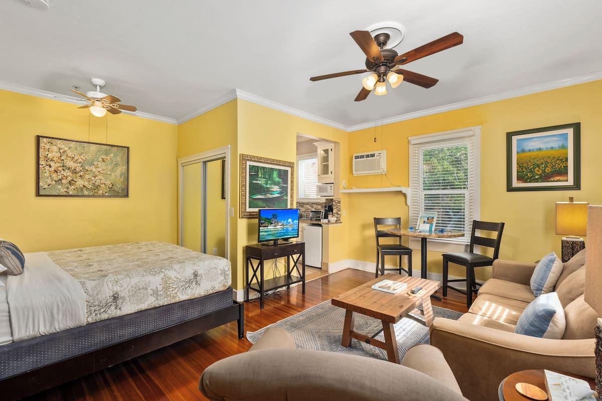 A compact living space with a bed, sofa, and a small dining area.