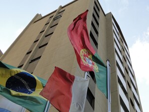 A building with multiple flags, including the Brazilian flag, and a flag with a coat of arms. - PREMIUM FLATS BERRINI - BOUTIQUE HOTEL & SPA (São Paulo)