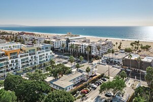 Zona costera urbana con playa, edificios modernos y cielo despejado.