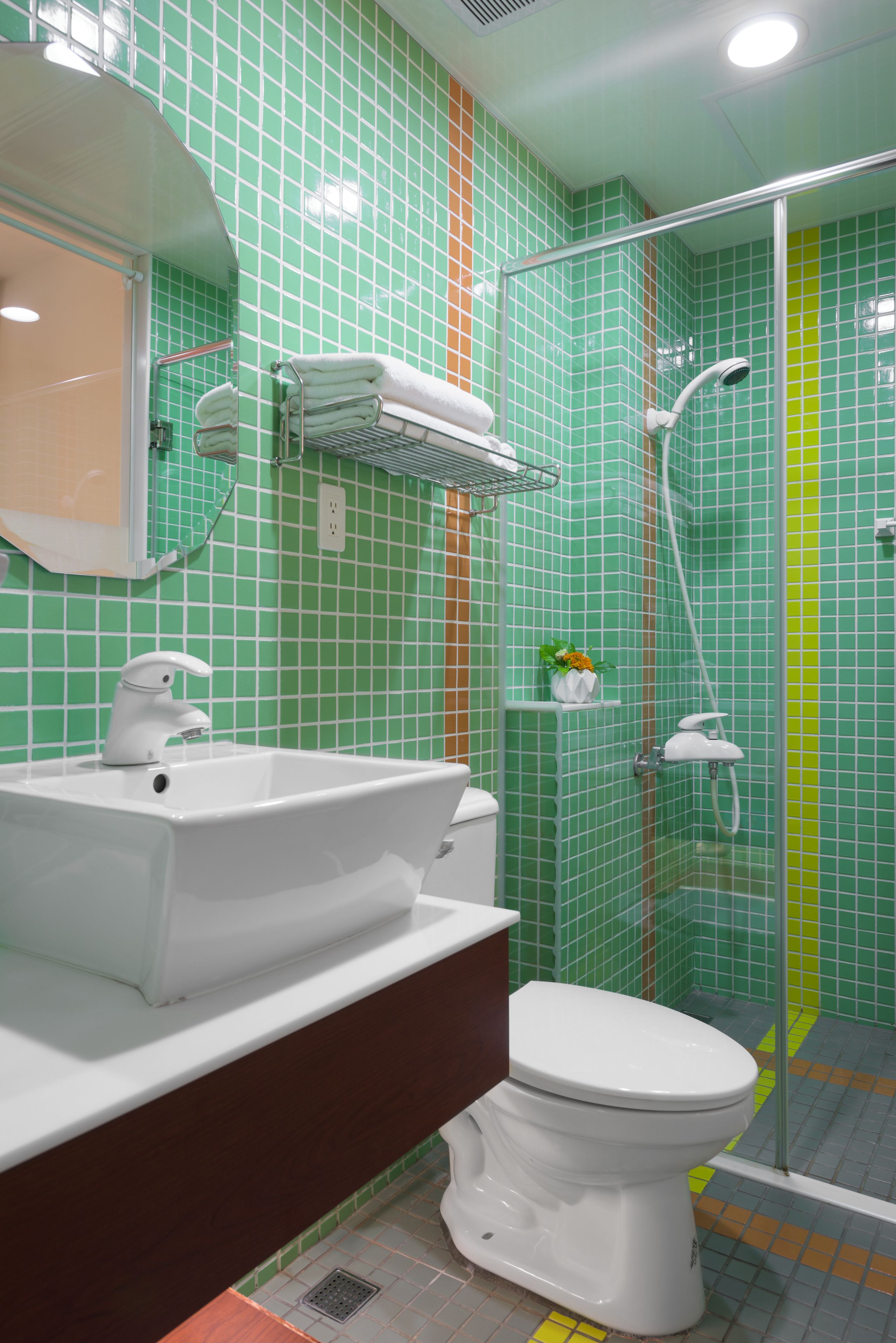 A bathroom with a white sink, toilet, and shower area.