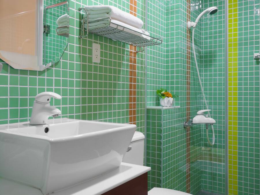 A bathroom with a white sink, toilet, and shower area.