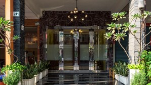 A modern building entrance with a stone facade, a glass door, and a staircase leading to the entrance. - Luna's House (Kaohsiung)