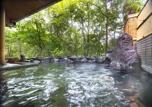 A hot spring area with a stone wall and a wooden structure. - Azumino Hotaka View Hotel (Azumino)