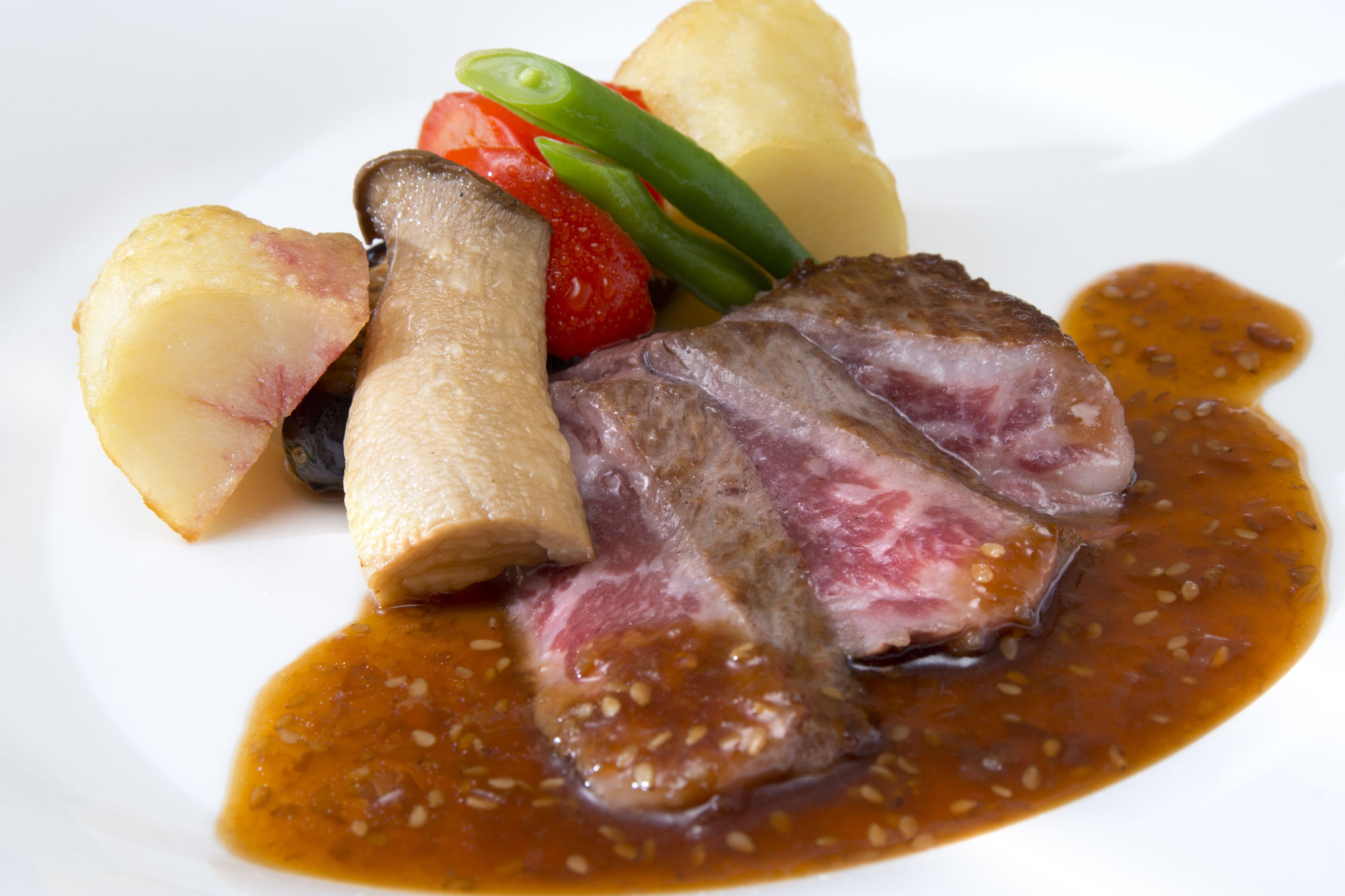 Ein Teller mit geschnittenem Fleisch, Kartoffeln und Gemüse.