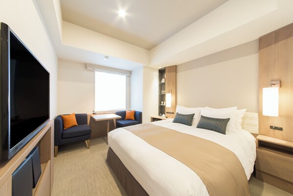 A hotel room with a large bed, a flat-screen TV, a desk, and a sofa. - Tokyu Stay Ginza (Tokyo)