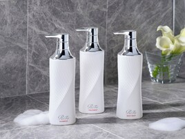 Three white bottles with pump dispensers on a tiled surface.