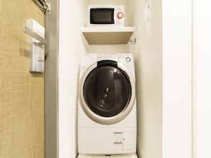 Convenient laundry facilities with a front-loading washing machine and microwave.