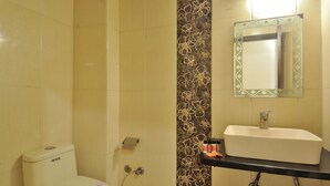 A bathroom with a toilet, sink, and mirror. - Hotel Sonu Dx New Delhi Railway Station (New Delhi)