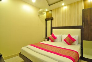 A hotel room with a bed, bedside table, and a mirror. - Hotel Sonu Dx New Delhi Railway Station (New Delhi)