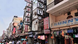 A busy street with various shops and signs, including a hotel and a guest house. - Hotel Sonu Dx New Delhi Railway Station (New Delhi)