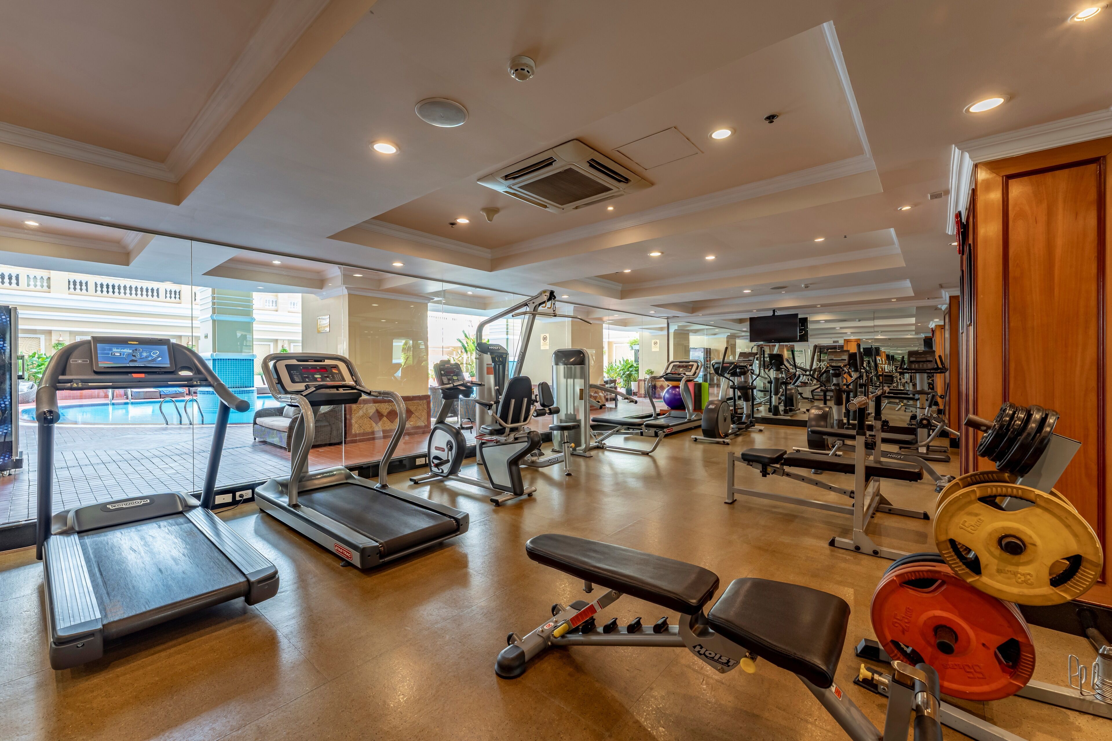 A spacious gym with treadmills, weight machines, and free weights.