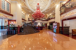 A grand lobby with a central staircase, a chandelier, and a reception desk. - Sherwood Residence (Ho Chi Minh City)