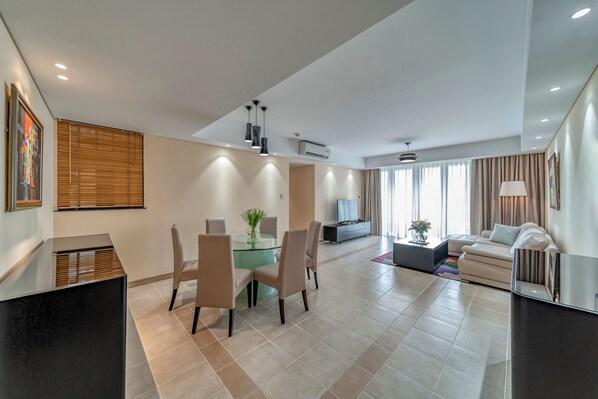 Una sala de estar moderna con comedor, sofá y televisor.