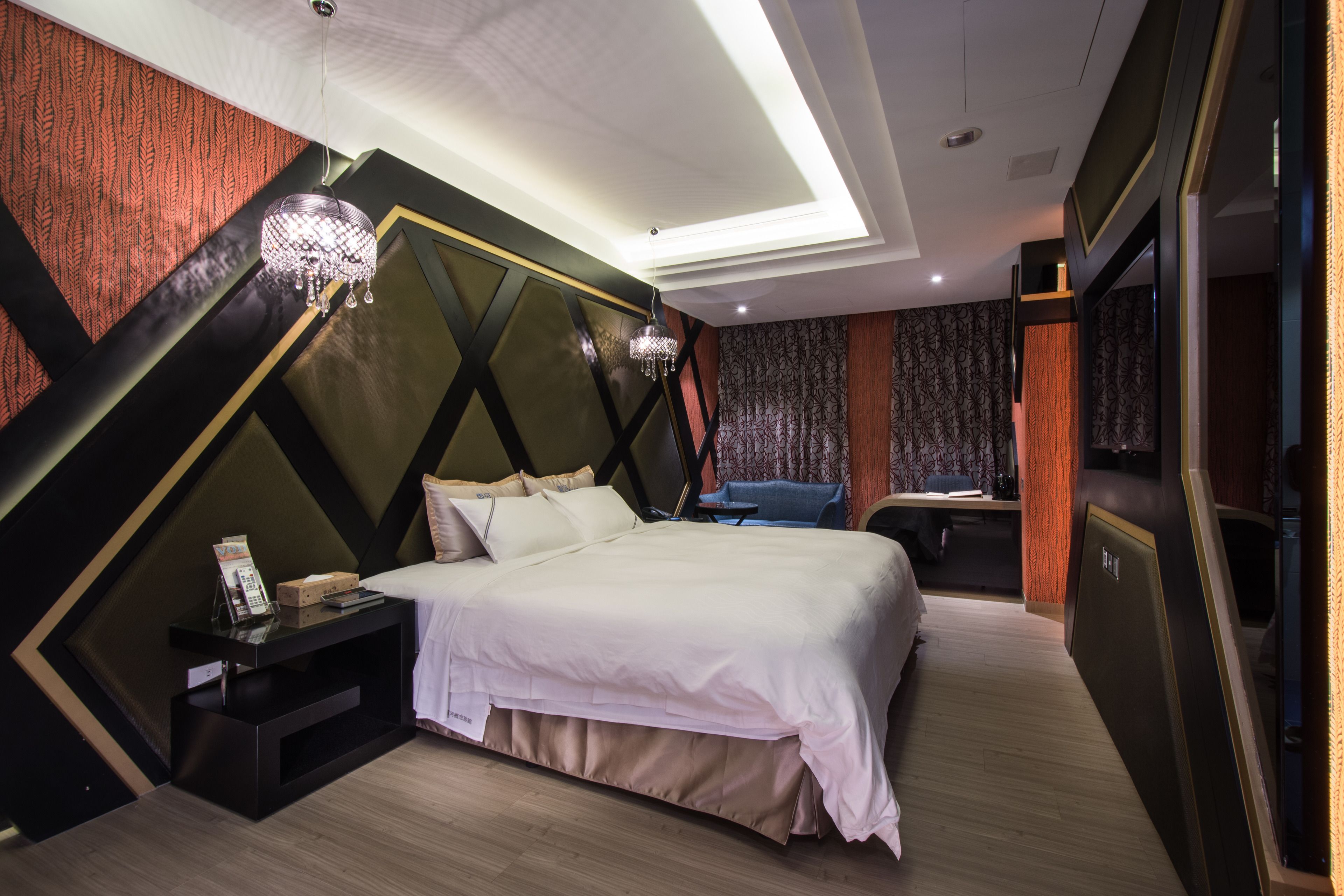 Une chambre d’hôtel moderne, dotée d’un grand lit, d’un bureau et d’un lustre.