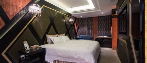 Une chambre d’hôtel moderne, dotée d’un grand lit, d’un bureau et d’un lustre.
